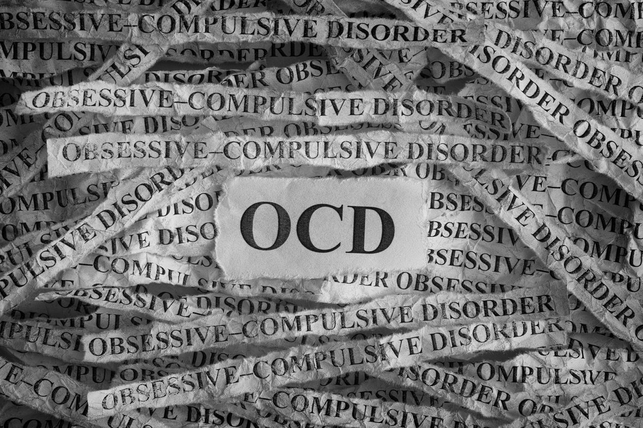 Obsessive compulsive disorder (OCD). Torn pieces of paper with the words Obsessive"u2013compulsive disorder. Concept Image. Black and White. Closeup.